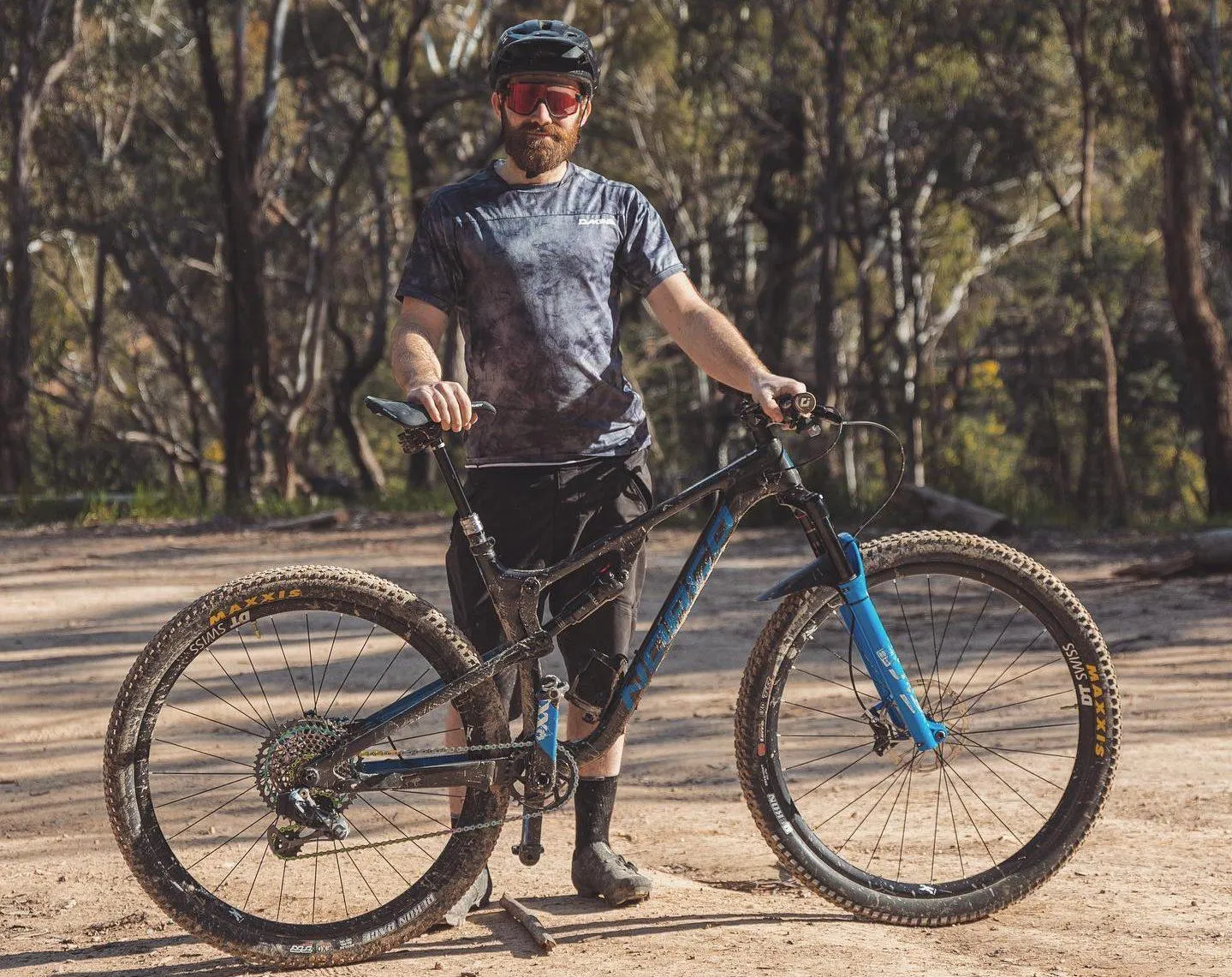 A cyclist standing with their bike